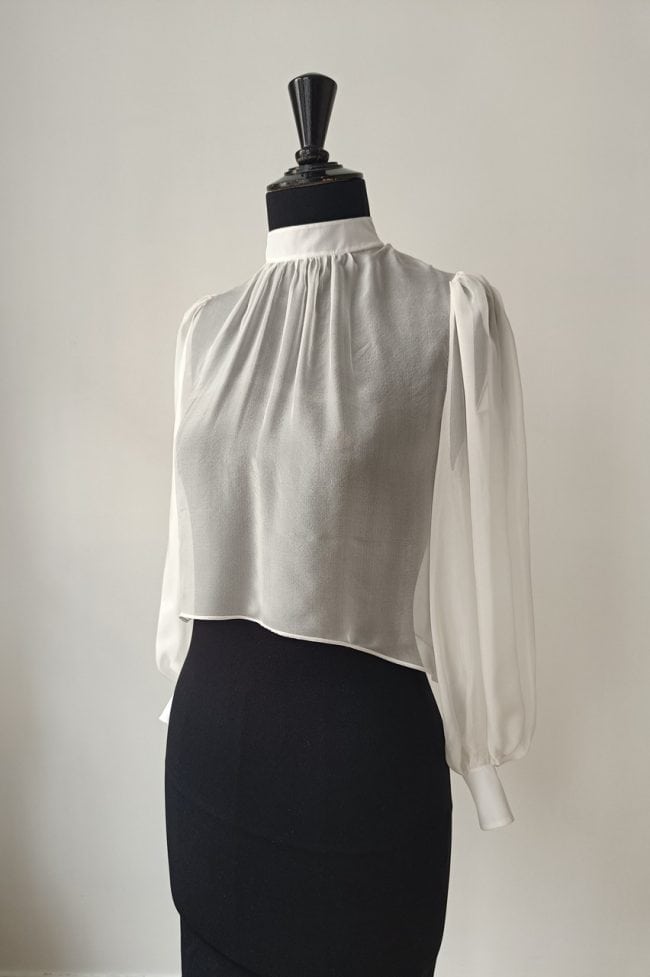 Blouse mariée en mousseline de soie avec col montant et manches longues ballon.