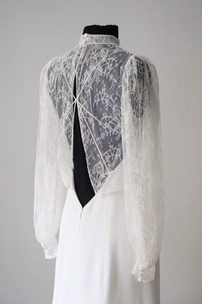 Blouse de mariée en dentelle de Calais avec col montant, manches longues ballon avec poignet chemisier, et ouverture au dos.